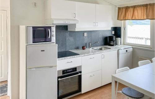 a kitchen with white cabinets and a sink and a microwave at Beautiful Home In Grythyttan With 1 Bedrooms in Grythyttan