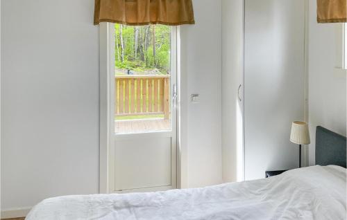 a bedroom with a bed and a sliding door with a window at Beautiful Home In Grythyttan With 1 Bedrooms in Grythyttan