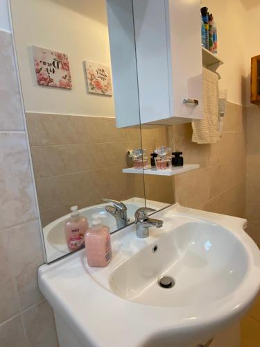 a bathroom with a white sink and a mirror at Lavender Cottage in Balatongyörök