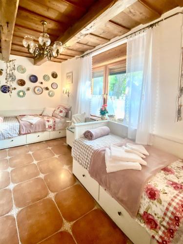 a bedroom with two beds and a window at Lavender Cottage in Balatongyörök