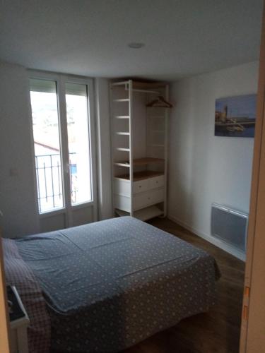 une chambre avec un lit et une étagère dans l'établissement La Maison Bleue, à Banyuls-sur-Mer