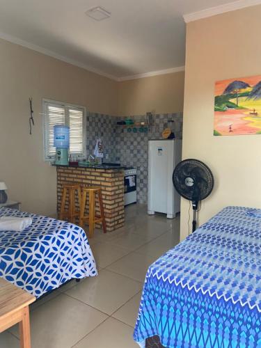 イカプイにあるChalés Girassolのベッドルーム1室(ベッド2台付)、キッチン(冷蔵庫付)
