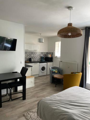 Habitación con cama, mesa y cocina. en Studio hypercentre 27m2 avec balcon et parking, en Aix-les-Bains