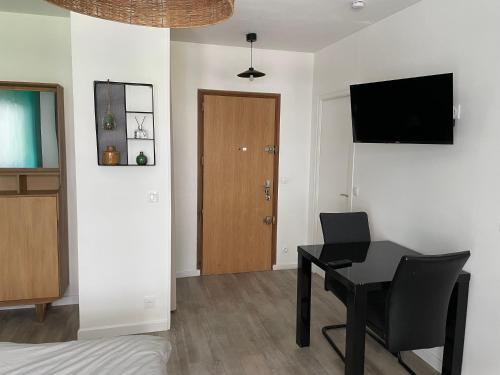 Cette chambre dispose d'un bureau et d'une télévision murale. dans l'établissement Studio hypercentre 27m2 avec balcon et parking, à Aix-les-Bains