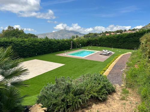 - un jardin avec une piscine au milieu dans l'établissement Sicilia tra cielo e mare con piscina, à Palerme