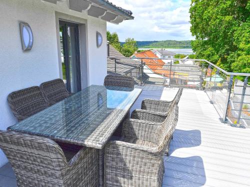 a patio with a table and chairs on a deck at Villa LEVANTE in Binz - Penthouse mit Kamin, Sauna, Seeblick in Binz
