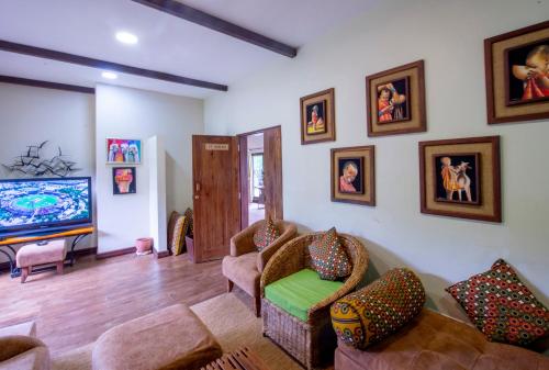 a living room with couches and a flat screen tv at The Retreat at Ngorongoro in Karatu