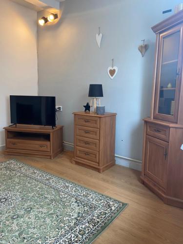 a living room with a flat screen tv and a dresser at Penzion U Radnice in Doksy