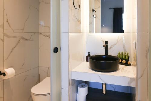 a bathroom with a sink and a toilet at Uphill Unique Boutique Suites in Skiathos Town
