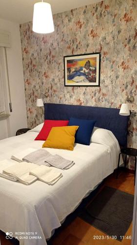 a bedroom with a large white bed with colorful wallpaper at IL BALCONE SUL LAGO in Magreglio