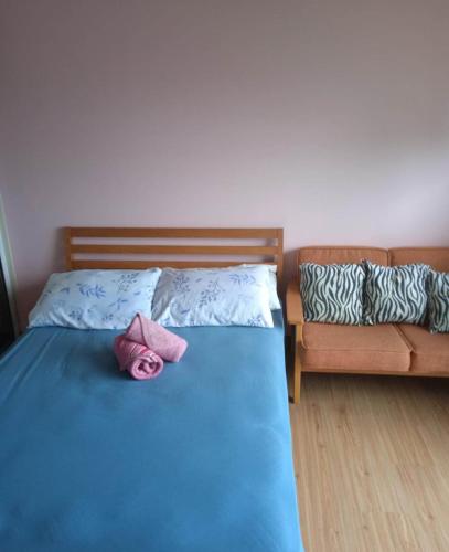 - une chambre avec un lit bleu et un canapé dans l'établissement SM Bicutan Condo Staycation, à Manille