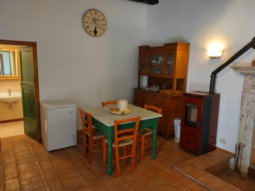 una cocina con mesa y sillas y un reloj en la pared en Casa nella Fortezza, en Pitigliano