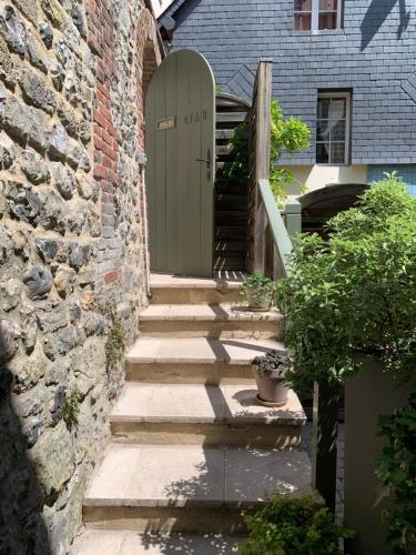 - un bâtiment en pierre avec une porte et des escaliers devant dans l'établissement Honfleur effet mer 1, à Honfleur