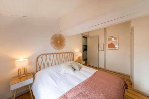 ein Schlafzimmer mit einem Bett und einem Tisch mit zwei Lampen in der Unterkunft Le Cosy magnifique T2 neuf Centre ville Gare 800 m in Agen