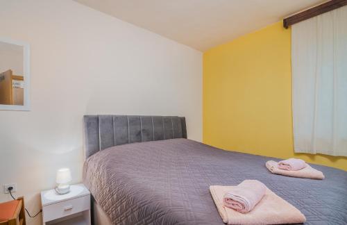 a bedroom with a bed with pink towels on it at Apartmani M in Baška