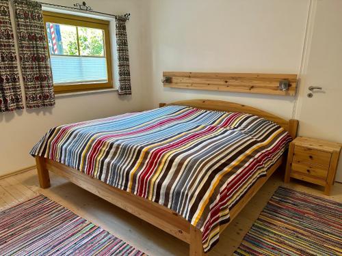 a bedroom with a bed with a colorful blanket on it at Ferienwohnungen Hänsel und Gretel - zentral, gemütlich, nah am See in Schliersee