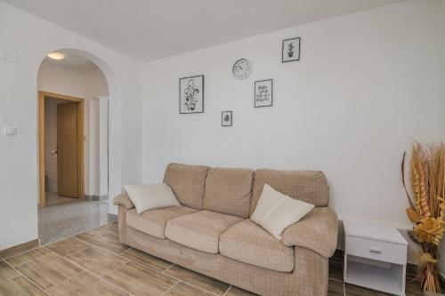 a living room with a couch and a white wall at Apartmani M in Baška