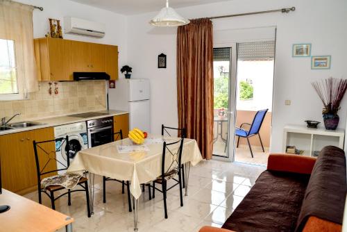 een keuken en een woonkamer met een tafel en stoelen bij ADONIOS APARTMENTS in Archangelos