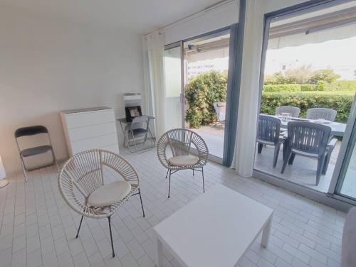 une chambre avec des chaises, une table et une terrasse dans l'établissement Belle terrasse a deux pas de la plage et parking prive, à La Grande Motte