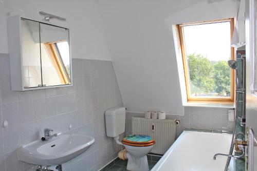 a bathroom with a sink and a toilet and a tub at Pension lichtenow in Rüdersdorf
