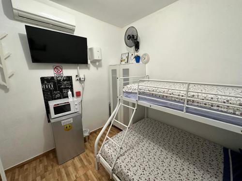a room with a bunk bed with a flat screen tv at CASA SUR APARCAMIENTO GRATIS in Córdoba