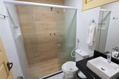 ein Bad mit einer Dusche, einem WC und einem Waschbecken in der Unterkunft Hotel Jangadas in Águas Belas