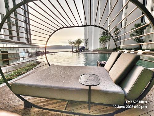 a couch sitting next to a pool in a building at Seaview Luxury Suites at The Shore Kota Kinabalu in Kota Kinabalu