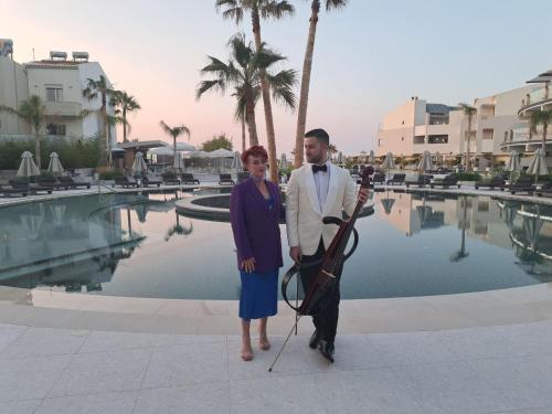 a man and a woman standing in front of a pool at Nautilux Rethymno by Mage Hotels in Rethymno Town
