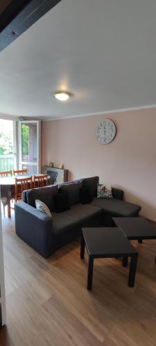 Una sala de estar con un sofá y un reloj en la pared. en Appartement Grand Paris, en Saint-Denis