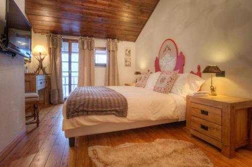 a bedroom with a bed and a dresser and a television at Locanda La Brenva - Estella Hotel Collection & Experience in Courmayeur