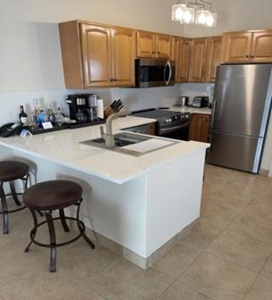 a kitchen with a sink and a refrigerator at Windsong on the Reef in Grace Bay