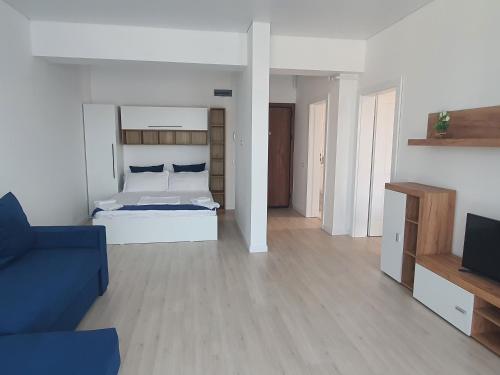 a bedroom with a white bed and a blue couch at Studio Alex in Năvodari