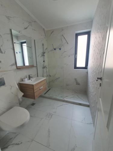 a white bathroom with a toilet and a sink at Studio Alex in Năvodari