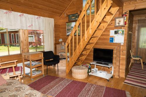 ein Wohnzimmer mit einer Treppe in einem Blockhaus in der Unterkunft Pihlajamäen Lomamökit in Vanhakylä