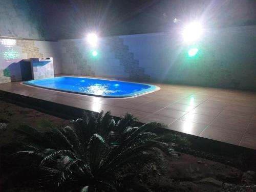 - une grande piscine bleue dans un bâtiment lumineux dans l'établissement Casa na praia com piscina e churrasqueira, à Itanhaém