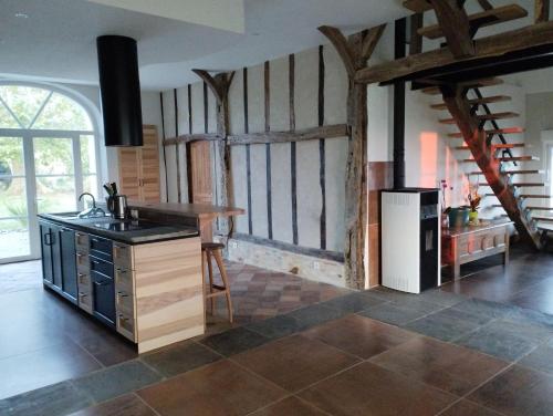 a kitchen with a counter and a refrigerator at La Coquille in Pouillon