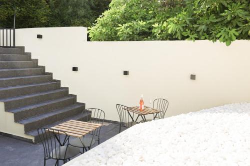 a patio with two tables and chairs and stairs at Uphill Unique Boutique Suites in Skiathos Town
