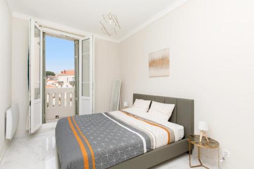 une chambre blanche avec un lit et une grande fenêtre dans l'établissement Bright and elegant renovated two rooms - Near Suquet, à Cannes