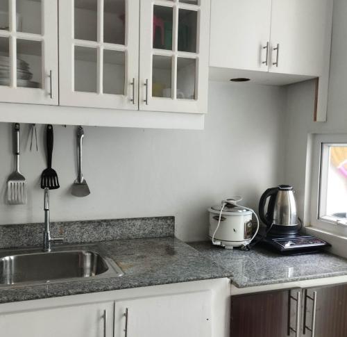 a kitchen with a sink and a toaster on the counter at Alabang Staycation in Manila