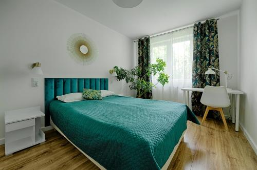 a bedroom with a green bed and a window at Apartamenty MM - Chmielna in Zielona Góra