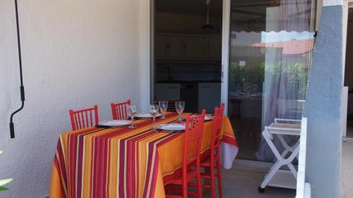une table avec un tissu de table rayé et des verres à vin dans l'établissement Appartement hippocampe bord de mer, au Barcarès
