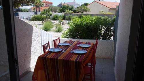 une table avec des assiettes et des plats dessus sur un balcon dans l'établissement Appartement hippocampe bord de mer, au Barcarès