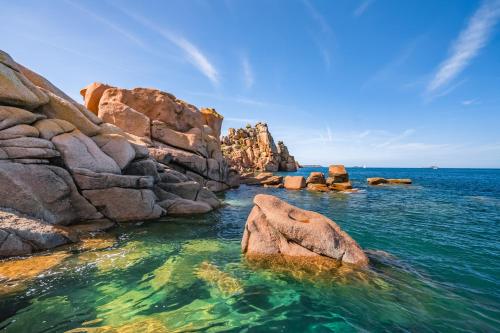 a group of rocks in the water near the ocean at Gites d'Armor in Treguidel