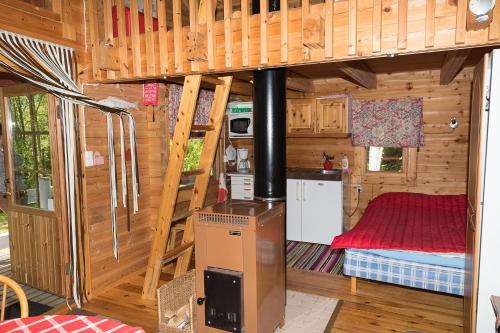 a room with a kitchen and a bed in a cabin at Pihlajamäen Lomamökit in Vanhakylä