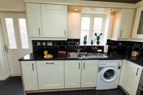 a kitchen with a sink and a washing machine at Cloudstays Birmingham Luxury Townhouse 2 lakes sleeps upto 8 Free Parking & WIFI in Birmingham