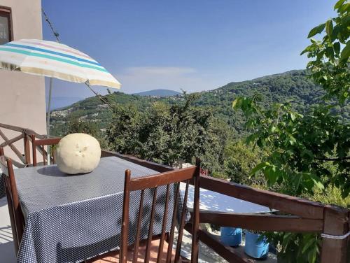 a table with an umbrella on a balcony with a view at Ξυλοπετρα / Wood & stone house in Tsagarada