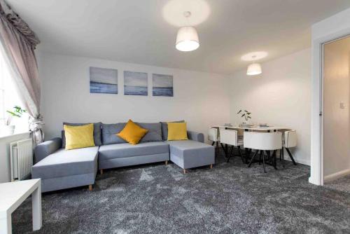 a living room with a blue couch and a table at Cloudstays Birmingham Luxury Townhouse 2 lakes sleeps upto 8 Free Parking & WIFI in Birmingham