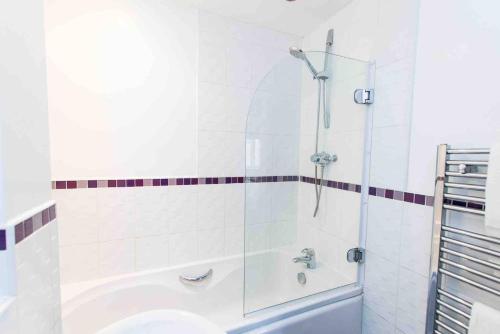 a bathroom with a shower and a tub with a sink at Cloudstays Birmingham Luxury Townhouse 2 lakes sleeps upto 8 Free Parking & WIFI in Birmingham