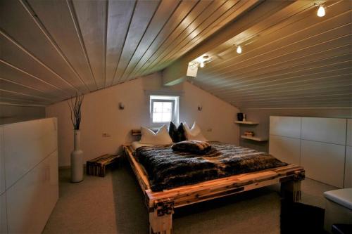a bedroom with a large bed with a wooden ceiling at Ferienwohnung Heimatglück 2-3 Personen WLAN in Breitbrunn am Chiemsee
