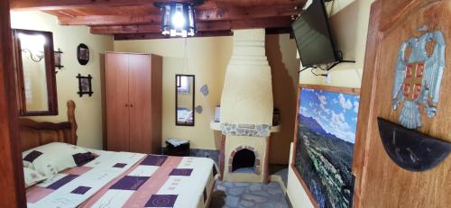 a bedroom with a bed and a tv and a fireplace at Koliba Oaza mira in Lopatnica